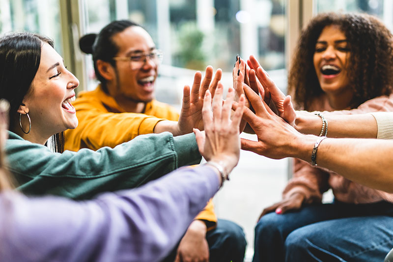 A group of teenagers joining their hands together.