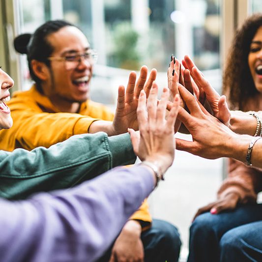 A group of teenagers joining their hands together.