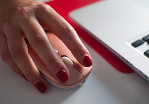 A woman's hand rests over a computer mouse.